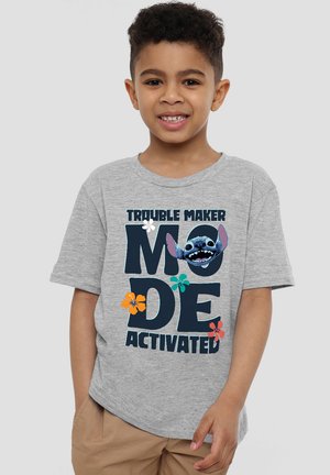 Grauem Baumwoll-T-Shirt mit grafischem Textdesign "STÖR_KIND_MODUS AKTIVIERT!" mit bunten floralen Akzenten und einer Charakterillustration.