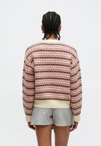 Suéter de punto con rayas horizontales en rosa, marrón y crema, con un acabado texturizado y puños y dobladillo acanalados.