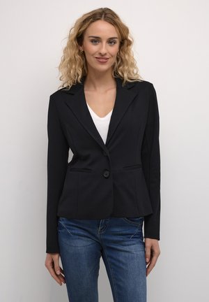 Navy blazer made of stretch fabric, featuring a single button closure, notched lapels, two front pockets, and fitted design. Casual look paired with denim.