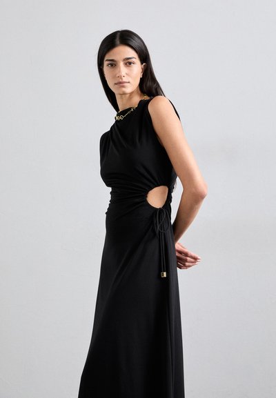 Rochie neagră cu design lateral plisat, având o decupare deschisă și detalii cu șiret. Material neted și moale, stil fără mâneci, aspect minimalist.