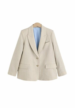 Beige pruhovaná sako s vyštípnutými klopami, dvěma knoflíky, klopovými kapsami a světle modrou podšívkou na dřevěném ramínku.