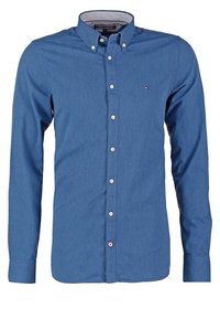 Camicia azzurra in denim, con colletto classico, maniche lunghe e un piccolo ricamo del logo sul petto.