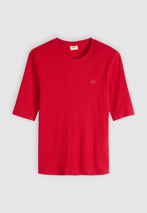 Rød kortærmet T-shirt med rund hals og ribstrikket tekstur samt lille Levi's-logo på venstre bryst mod en ensfarvet lys grå baggrund.