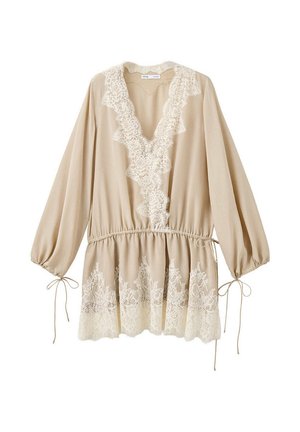 Beige blouse met lange mouwen, diepe V-hals, kanten rand langs de halslijn en zoom, elastische taille en strikjes bij de mouwboorden.