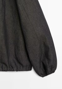 Donkergrijze trui met lange mouwen, elastische manchetten en tailleband, met een zichtbare stofstructuur en stikdetails.