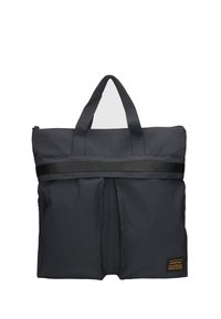 Sac fourre-tout en tissu noir avec des poignées supérieures doubles, design épuré, fermeture éclair argentée, large sangle noire, devant plissé et étiquette de marque sur le côté.