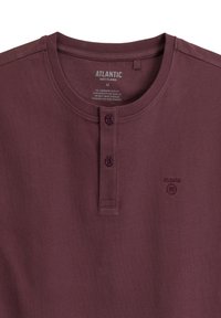Bordowy męski top piżamy z okrągłym dekoltem, trzema guzikami oraz haftowanym logo na piersi. Miękka, gładka faktura materiału.