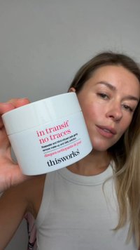 Białe okrągłe opakowanie z napisem "in transit no traces" różowym tekstem, zawierające płatki oczyszczające nasączone różaną wodą i miętą.