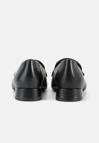 Μαύρα δερμάτινα παπούτσια με λεία υφή, στρογγυλεμένο σχήμα και χαμηλά τακούνια μπλοκ, με διακριτικές ραφές στο πάνω μέρος.