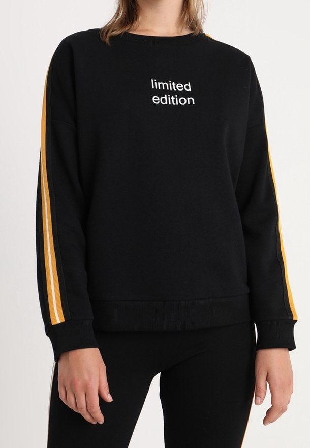 Sweatshirt noir avec le texte « édition limitée », présentant des détails à rayures jaunes le long des manches. Fabriqué en tissu doux avec une coupe décontractée.
