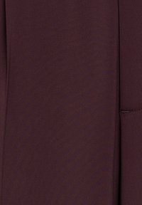 Bordeauxstof met een gladde, licht gestructureerde afwerking. Heeft nette lijnen en nauwkeurige maatwerk, geschikt voor formele kleding.
