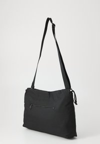 Black crossbody bag made of soft fabric with a zippered front pocket, adjustable strap, and a smooth texture. Simple, rectangular shape.