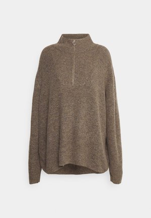 Brązowy sweter dzianinowy z kołnierzem w formie lejka, z prążkowaną teksturą i półzamkiem z okrągłym uchwytem. Luźny krój z opadającymi ramionami.
