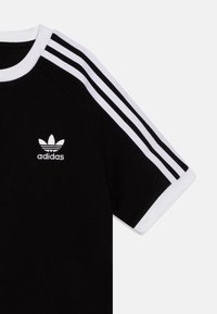 Black t-shirt with white collar and three white stripes on sleeves. Features an embroidered white Adidas logo on the chest.