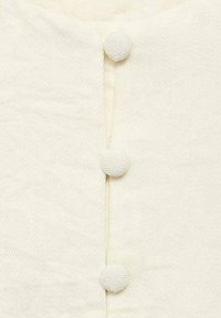 Weißer, strukturierter Stoff mit drei verdeckten Knöpfen entlang der Vorderseite. Das Design beinhaltet ein dezentes diagonales Webmuster.