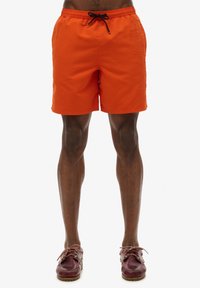 Bañador naranja con cintura elástica y cordón negro. Presenta un estampado de logo en el lateral y está hecho de una tela suave y ligera.