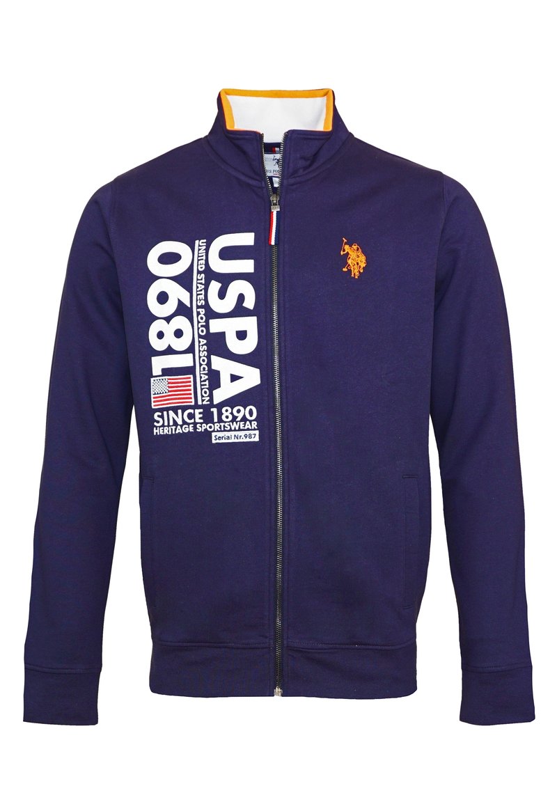 Mörkblå zip-up jacka med orange kragepålägg, USPA-logotyp, stor vit text "USPA 1890" och en liten orange polo-spelare emblem.