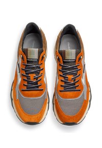 Sneaker in rete grigia e suede arancio con tacco in suede marrone, lacci blu navy e dettagli testurizzati. Suola spessa e imbottita per il comfort.