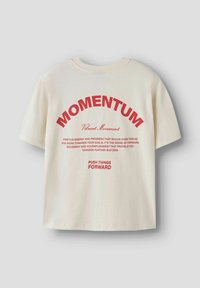 Kremowa koszulka z krótkim rękawem z czerwonym nadrukiem. Wzór zawiera napis "MOMENTUM" łukiem nad mniejszym tekstem oraz hasło poniżej.