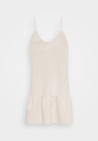 Beige ärmlös klänning med tunna axelremmar, V-ringning, texturerad tyg och en rynkad volangkant i botten.