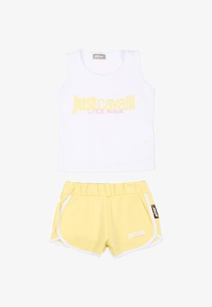Wit mouwloos topje met de tekst "Just Cavalli Little Rogue", gecombineerd met gele shorts met elastische taille, witte bies en "Just Cavalli" logo.