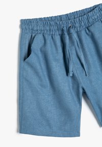 Lysblå shorts med elastisk talje, snor lukning, sidelommer og en struktureret stof. Har rene sømme og et afslappet design.