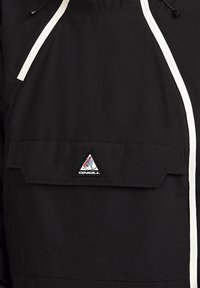 Vêtement noir avec une poche avant avec un écusson triangulaire du logo O'Neill et des rayures verticales blanches le long des côtés.