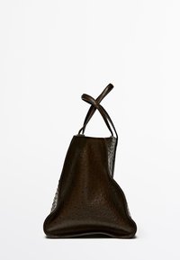 Brown leather bag with a textured surface, featuring a triangular shape and crossbody straps. Notable for its distinctive pattern and sleek design.
