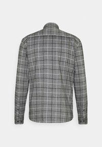 Camicia a maniche lunghe grigia con motivo a quadri bianco e nero. Dettagli con bottoni sui polsini, colletto strutturato e tessuto dalla texture liscia.