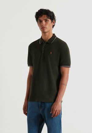 Donkergroen poloshirt met een zwart-wit gestreepte kraag, drie-knopenlijst en geborduurd logo op de borst. Draagt u met blauwe jeans.