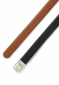 Bruine en zwarte leren riemen gerangschikt, met gladde texturen, een zilveren metalen gesp en zichtbare bevestigingsgaten op de bruine riem.