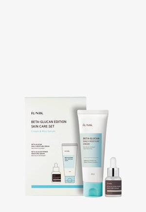 Set per la cura della pelle iUNIK Beta-Glucan Edition con tubo di crema idratante quotidiana e flacone contagocce di siero idratante potente accanto alla confezione del prodotto.