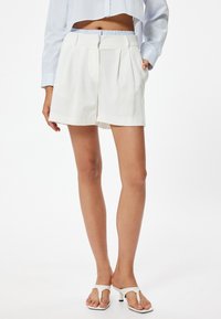 Hvide shorts med elastisk talje, plisseret front, sidelommer og en afslappet pasform. Glat stof med en ren finish.