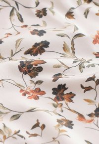 Hele kangaga, millel on lillemustrid tumepruunide, oranžide ja roheliste elementidega helel kreemjal taustal. Sile tekstuur, õrn disain.