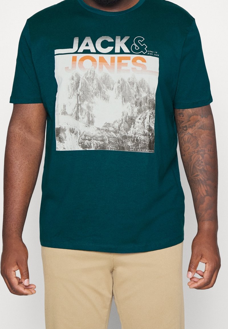 Teal cotton t-shirt featuring a graphic print of mountains, with text "JACK & JONES" in bold white and orange lettering above the image.