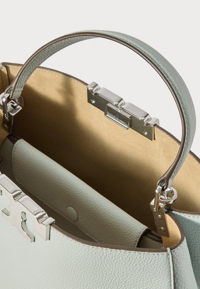 Lys blå læderhåndtaske med et struktureret design, sølvfarvet hardware-lås og en glat indvendig del. Har et behageligt greb-håndtag.