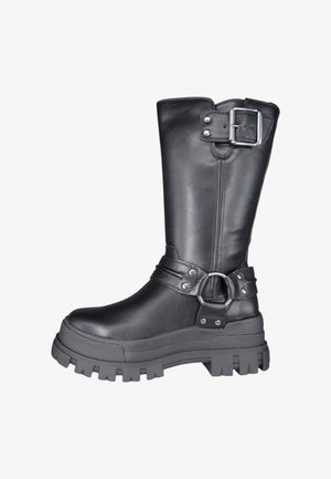 Bota de cuero negro hasta la rodilla con suela gruesa, detalle de hebilla plateada y una correa con un acento circular. Textura suave y diseño resistente.