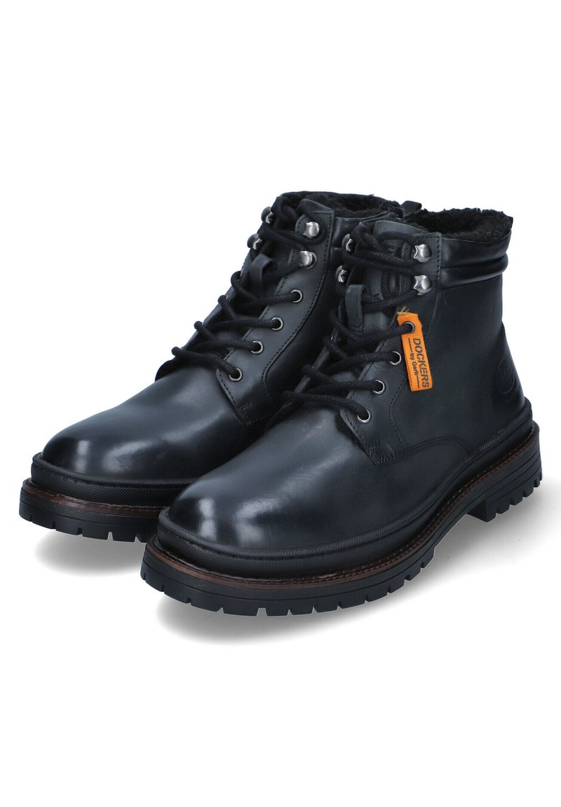 Botas de tobillo de cuero negro con textura suave, punteras redondas, cordones en la parte delantera, ojales de metal y suela de goma. Presentan un cuello forrado de pelo.