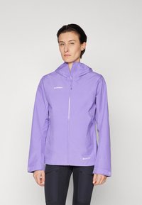 Fioletowa kurtka GORE-TEX z kapturem, przednim zamkiem błyskawicznym i bocznymi kieszeniami. Charakteryzuje się matowym wykończeniem i minimalnym logo na piersi.