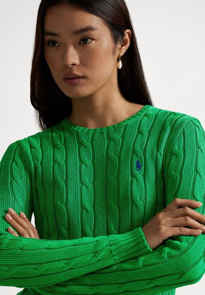 Lysegrønn kabelstrikket genser med lange ermer og rund hals. Har en liten blå logo på brystet. Glatt tekstur.