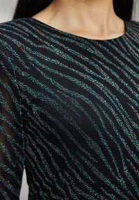 Černá látka s vodorovnými vícebarevnými pruhy v modré, červené a stříbrné akcenty; hladká textura a přiléhavý design.