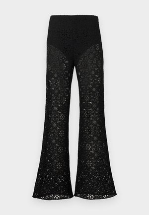 Fekete, magasított derekú csipkés nadrág, bővülő szárakkal, virágmintás kivágásokkal az egész anyagon.