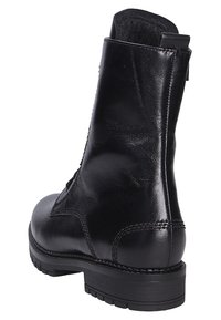 Schwarze Leder-Ankle-Boots mit glatter Oberfläche, runder Zehenpartie, kontrastierenden Nähten und einer niedrigen Gummisohle. Mit einem Rückziehband für ein einfaches An- und Ausziehen.