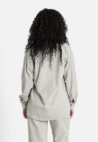 Gestreiftes Hemd in Hellgrau und Creme, mit lockerer Passform, langen Ärmeln und rundem Saum, kombiniert mit passenden gestreiften Hosen.