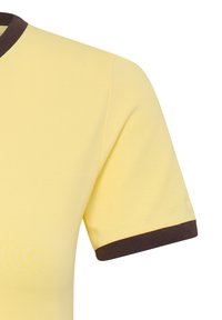Chemise jaune à manches courtes avec col et poignets marron foncé, montrée de l'épaule jusqu'au milieu du torse sur fond blanc.