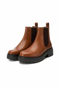 Stivali alla caviglia in pelle marrone con pannelli elastici laterali, suole in gomma nera testurizzata e linguette per una facile calzata. Finitura liscia con accenti minimi.