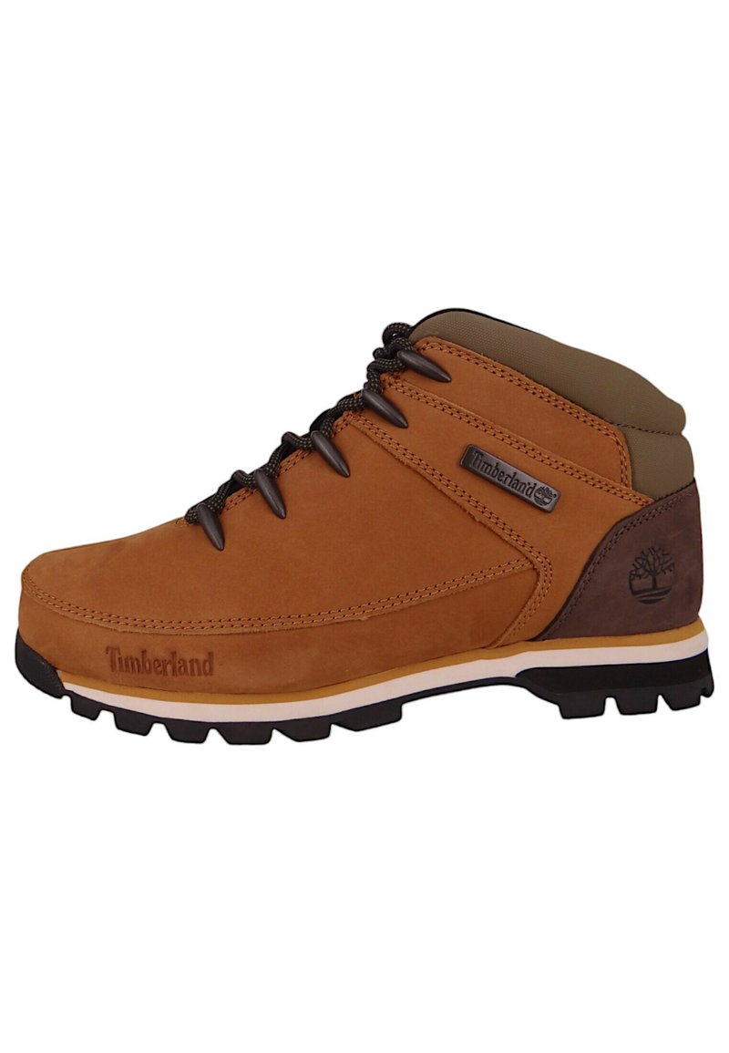 Brązowy zamszowy but wędrówkowy z wyściółką przy kołnierzu, czarnym sznurowaniem, gumową podeszwą oraz detalem logo Timberland z boku.
