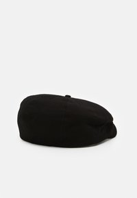 Casquette noire à motif chevron, de forme arrondie, en tissu doux, avec un petit bouton sur le dessus, affichant un design simple et élégant.