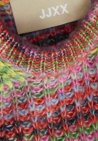 Maglione lavorato a maglia multicolore con scollatura rotonda. Il materiale sembra testurizzato con filato morbido in tonalità di rosso, verde, rosa e blu.