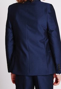 Granatowa marynarka garniturowa o gładkiej teksturze, z jednym rozcięciem z tyłu i pięcioma guzikami na rękawach.